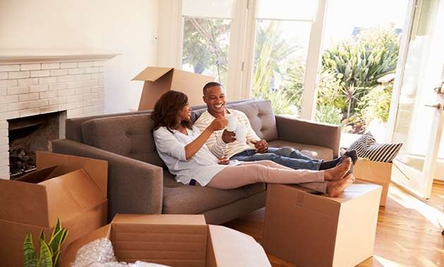 A couple sitting on the sofa after moving into their new smart home.